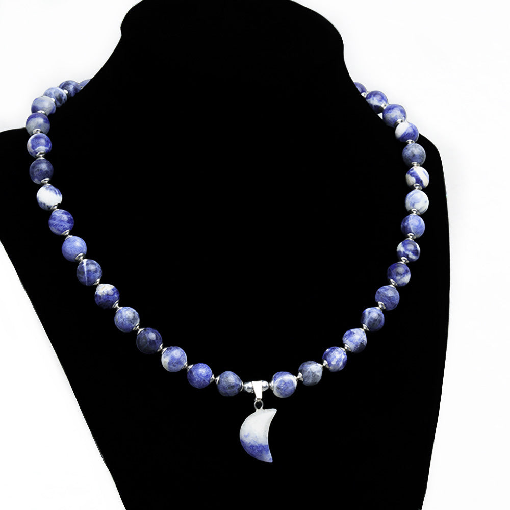 Look beautiful and feel powerful with this Sodalite Beaded Gemstone Necklace with its mesmerizing moon-shaped gemstone pendant. Crafted with 8mm blue Sodalite beads and16-inch length, it's the perfect way to showcase your unique style and express yourself.  Size: 16" Length with 2" Chain Extender. 8mm Gemstone Beads.  Material: Natural Sodalite & Blue Spot Jasper with Platinum Colored Stainless Steel Spacers.