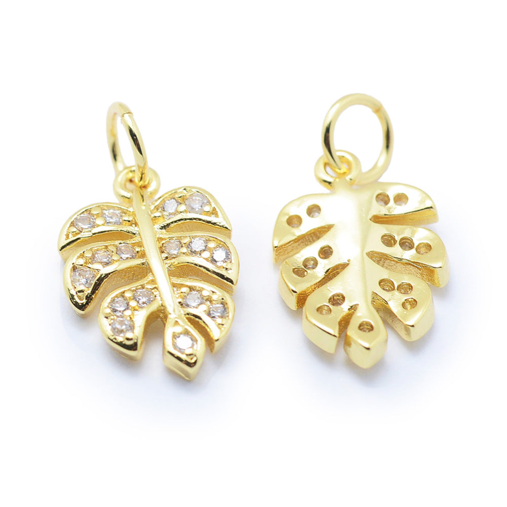 Tropical Leaf Charms, Brass Micro Pave Cubic Zirconia Clear & Gold Color Monstera Leaf Charms for DIY Jewelry Making.   Size: 14mm Length, 9mm Width, 2mm Thick, Hole: 3mm, Quantity: 1pcs/package.  Material: Cubic Zirconia Brass Micro Pave Tree Charm with Jump Ring. Gold Color.