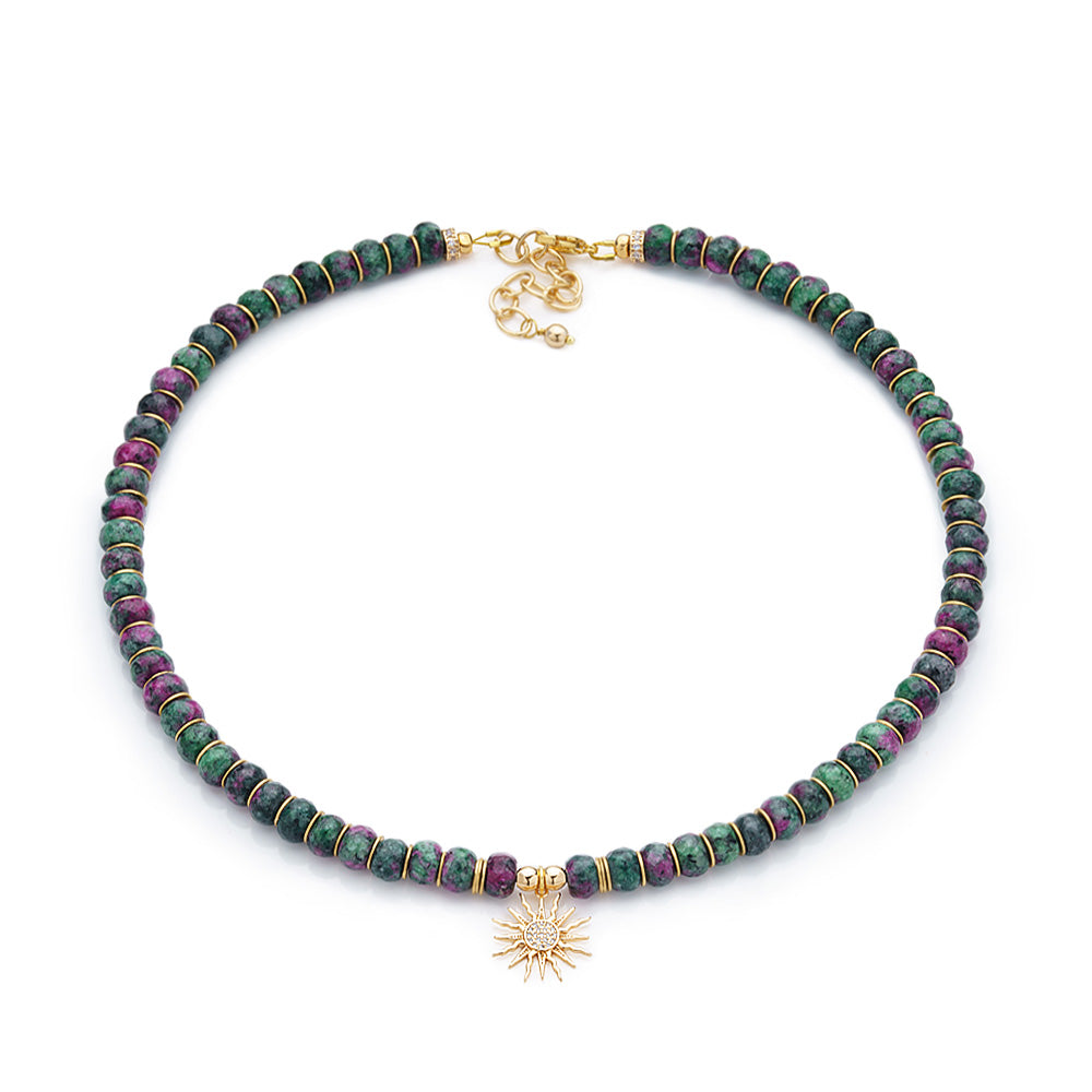 This Ruby Zoisite necklace set is a thing of beauty and elegance. Hand crafted with 8mm faceted rondelle beads, 18K Gold Plated disc spacer beads and a Cubic Zirconia Solar Eclipse Sun Charm, this stunning piece of jewelry is sure to captivate onlookers. 