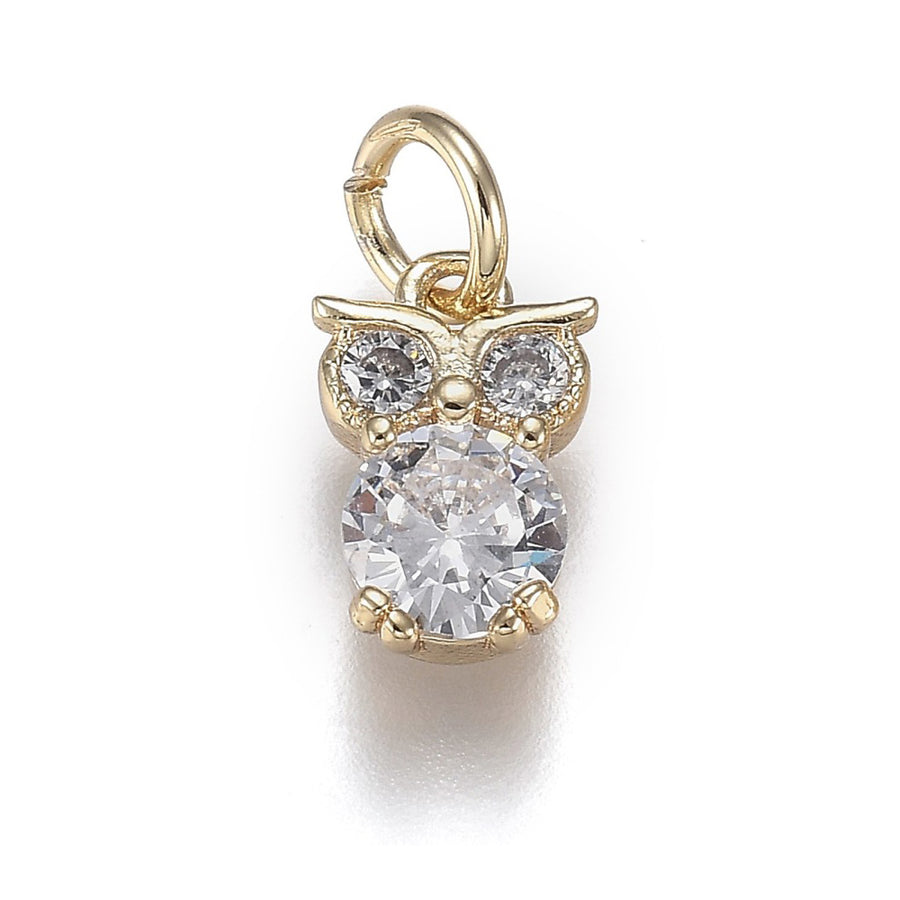 Elevate your jewelry designs with these stunning Cubic Zirconia Owl Charms. Crafted from brass and finished with 18k gold plating, each pendant features brilliant micro pave cubic zirconia stones that catch the light beautifully. The charming owl shape adds character and whimsy to bracelets, necklaces, and earrings.

At 12x8x3.5mm, these petite pendants are perfectly sized for delicate jewelry projects. Pre-attached jump rings make assembly effortless. Durable and long-lasting, these high-quality charms are