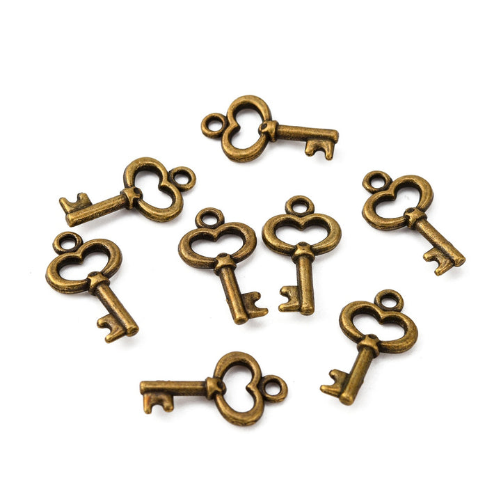 Skeleton Key Charms, Antique Bronze Colored Key Shaped Charms for DIY Jewelry Making.   Size: 9mm Width, 15.5mm Length, 2.5mm Thick, Hole: 1mm, Quantity: 10 pcs/package.   Material: Alloy (Lead, Cadmium & Nickel Free) Charms. Bronze Color. 