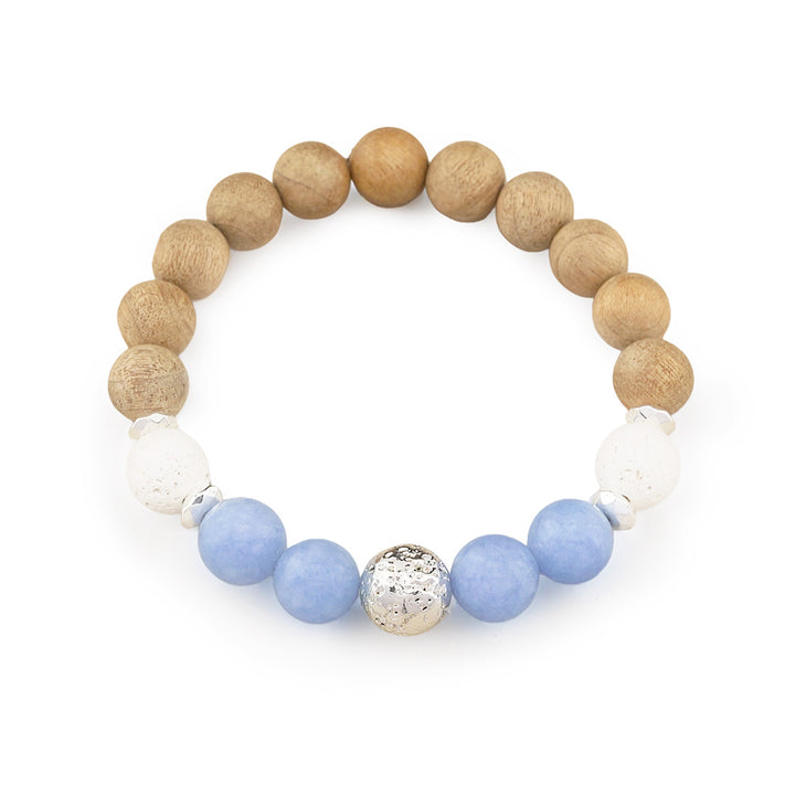 A beaded stretch bracelet featuring natural wood beads, white textured beads, light blue beads, and a central hammered silver accent bead, displayed on a clean white background.