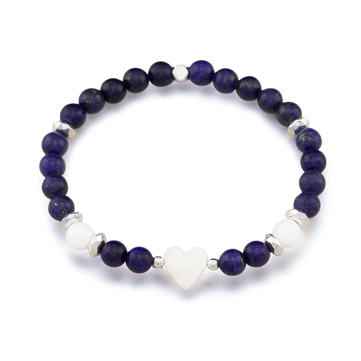 A beaded stretch bracelet featuring dark blue lapis lazuli stones, white agate beads, and a central white heart charm, accented with small silver spacer beads, shown on a white background.