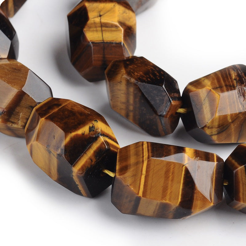 Discover the treasures of nature with these exquisite Tiger Eye Beads! These genuine gemstones sparkle in deep, dark Gold, Yellow and Brown hues, giving it a cat eye effect. Perfect for adding a magical touch to any jewelry design. With sizes ranging between 15-22x8-17mm, these large nuggets are sure to provide an eye-catching sparkle. Get creative and explore the beauty of these amazing semi-precious stones!