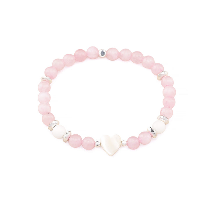 A beaded stretch bracelet featuring light pink round beads, a white heart-shaped bead, and small silver metallic spacer beads, displayed on a clean white background.