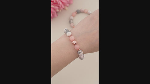 Trendy Matte Frosted Pink Zebra Jasper, Sunstone &amp; Rose Gold Lava Rock Beaded Gemstone Stretch Bracelet.

This bold and stylish Chunky Beaded Stretch Bracelet features a mix of 10mm matte frosted Pink Zebra Jasper, 10mm frosted Sunstone, and showcasing a 10mm electroplated rose gold Lava Rock bead as the focal point. The bracelet is accented with 6mm rose gold faceted rondelle hematite beads, with a 10mm rose gold hematite bead as the striking centerpiece, making it the perfect focal 