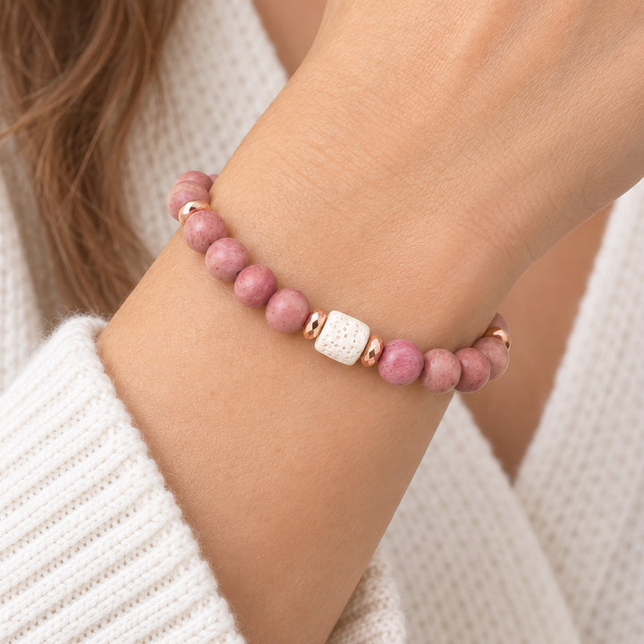 This handmade rhodonite bracelet combines 8mm rhodonite beads with a striking white lava rock focal bead and rose gold hematite spacer accents for a design that balances natural beauty with refined elegance. Perfect for everyday wear or as a meaningful gift for someone on a healing journey.