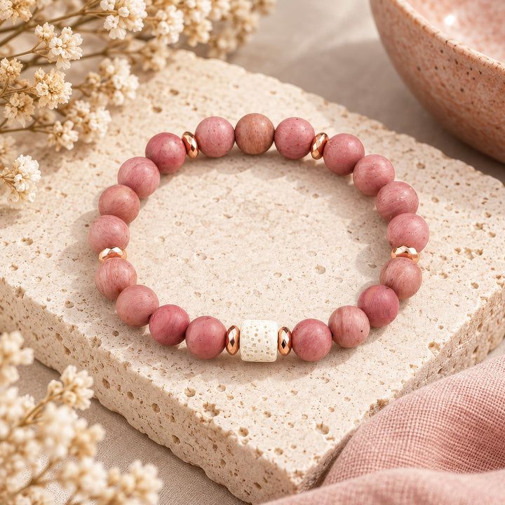 This handmade rhodonite bracelet combines 8mm rhodonite beads with a striking white lava rock focal bead and rose gold hematite spacer accents for a design that balances natural beauty with refined elegance. Perfect for everyday wear or as a meaningful gift for someone on a healing journey.