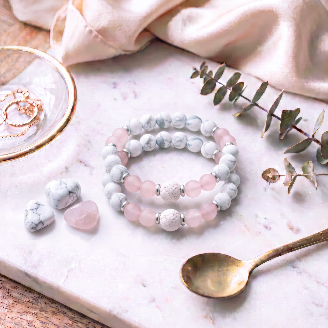 This charming bracelet is adorned with beaded gemstones, including 8mm Matte White Howlite, 8mm Rose Quartz, and 10mm White Lava Rock beads, complemented by silver-toned spacers. These mala bracelets are versatile, perfect for wearing alone or layering for a bohemian look. Ideal for any occasion or casual daily wear, they pair well with numerous styles.