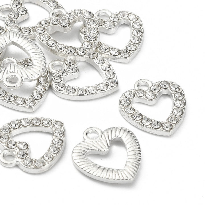 Silver Alloy Rhinestone Heart Charms for Jewelry Making.  Size: 14mm Length, 12.5mm Width, 2.5mm Thick, Hole: 2mm, Qty: 5pcs/package.   Material: Alloy Rhinestone Crystal Heart Shaped Charms. Silver Color with Clear Rhinestones. Shinny Polished Finish.