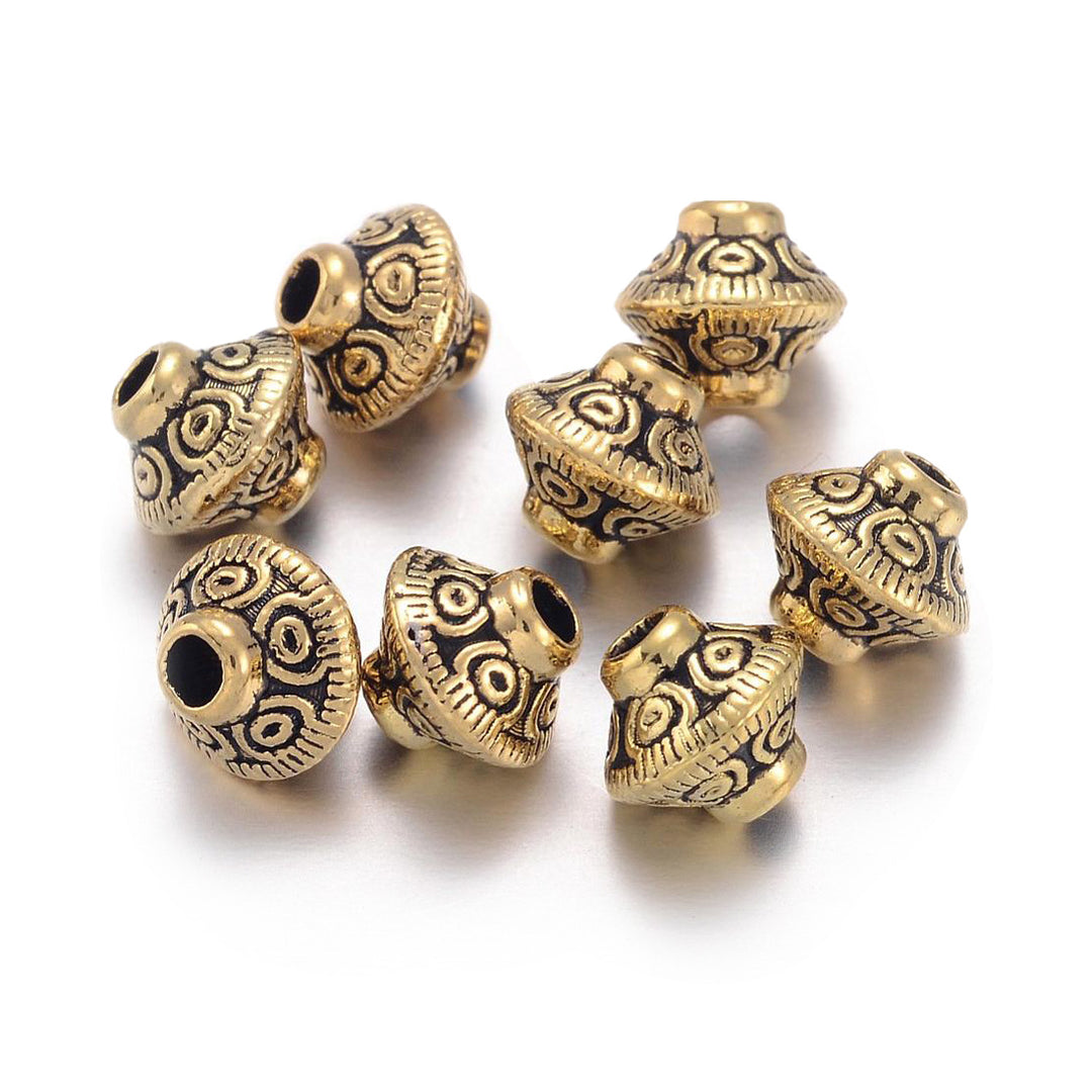 Tibetan Spacer Beads, Bicone, Antique Gold Color. Gold Spacers for DIY Jewelry Making Projects.   Size: 6.5mm Diameter, 7.5mm Width, Hole: 1mm, approx. 25pcs/bag.   Material: Antique Gold Alloy Spacers. 100% Lead, Cadmium and Nickel Free Spacers.