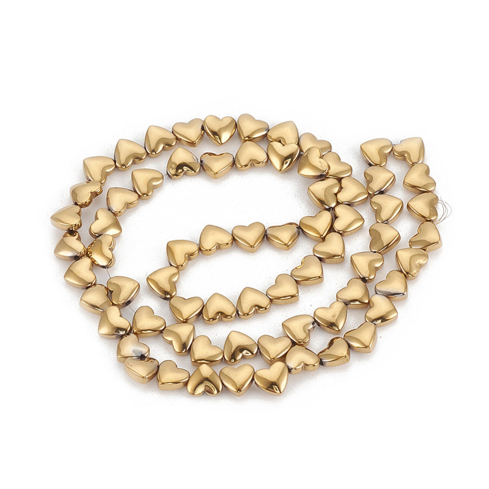 Non-Magnetic Hearth Shaped Synthetic Hematite Beads, Gold Color. Semi-Precious Stone Spacer Beads for Jewelry Making.   Size: 7mm Length, 5.5mm Width, Hole: 1mm, approx. 68-70pcs/strand, 15" Inches Long.  Material: Non-Magnetic Synthetic Hematite Beads. Gold Plated Flat Heart Shaped Spacer Beads. Polished, Shinny Metallic Lustrous Finish.