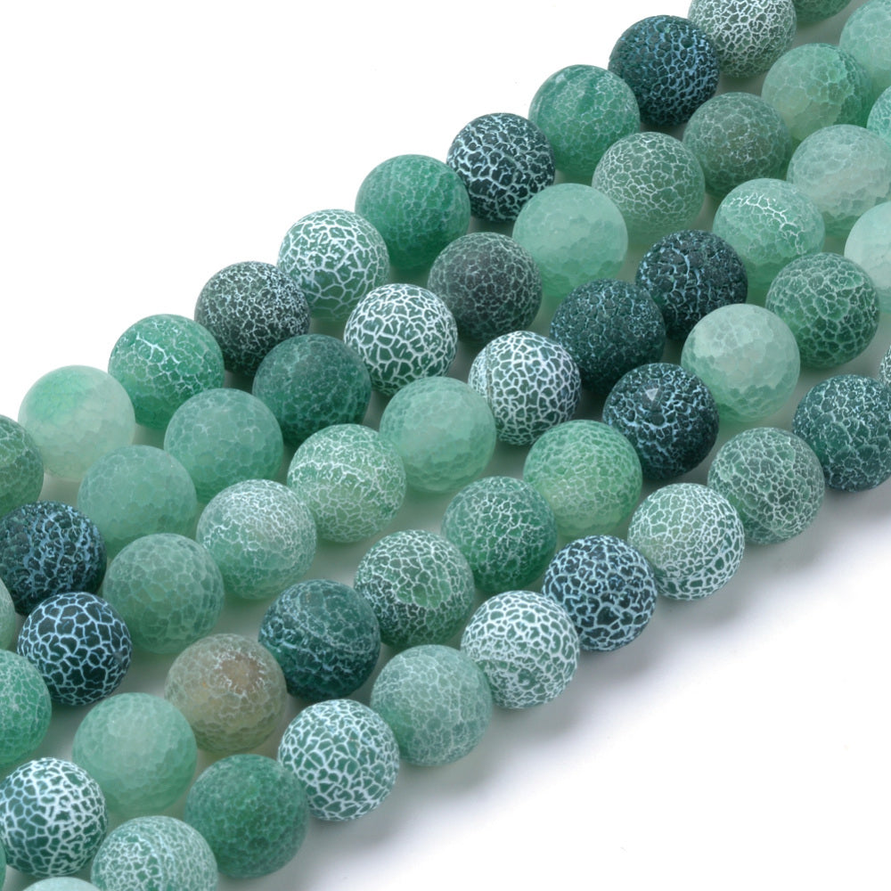 Natural Crackle Agate Beads, Dyed, Round, Green Color. Matte Semi-Precious Gemstone Beads for Jewelry Making. Great for Stretch Bracelets and Necklaces.  Size: 8mm Diameter, Hole: 1mm; approx. 47pcs/strand, 14.5" Inches Long.  Material: Natural & Dyed Crackle Agate, Frosted Green Color with White Crackle Pattern. The Crackle Appearance is Created by Heating the Stone to Extreme Temperatures. Unpolished, Matte Finish.