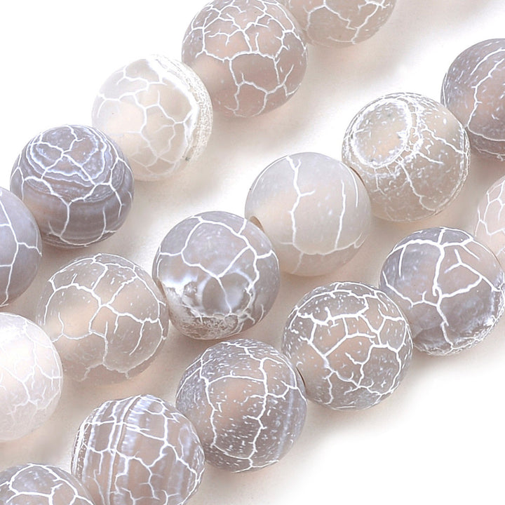 Natural Crackle Agate Beads, Dyed, Round, Grey Color. Matte Semi-Precious Gemstone Beads for Jewelry Making. Great for Stretch Bracelets and Necklaces.  Size: 8mm Diameter, Hole: 1mm; approx. 47pcs/strand, 14.5" Inches Long.  Material: Natural & Dyed Crackle Agate, Frosted Grey Color with White Crackle Pattern. The Crackle Appearance is Created by Heating the Stone to Extreme Temperatures. Unpolished, Matte Finish.