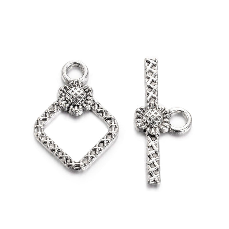 Rhombus with Flower Design Toggle Clasps for DIY Jewelry Making.  Size: 21mm Length, 15mm Width; Bar: 24x10mm, Hole: 2mm, 5 set/package.  Material: Antique Silver Color Alloy Toggle Clasps, Cadmium and Lead Free.   Usage: These Clasp are used to finish off necklaces or bracelets.